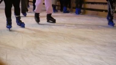 Ukrayna. Kyiv. 12.2021: Bir grup isimsiz insan buz pateni, halka açık buz pateni pisti, bacaklar yakın çekim, buz pisti yaşam tarzı çekimi. Sağlıklı kış sporları, tanınmayan insanlar, hareket