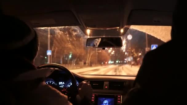 在一个漆黑的雪城里 一辆汽车在大雪中行驶 司机开车时 可以看到车内有夜灯和雨声 — 图库视频影像