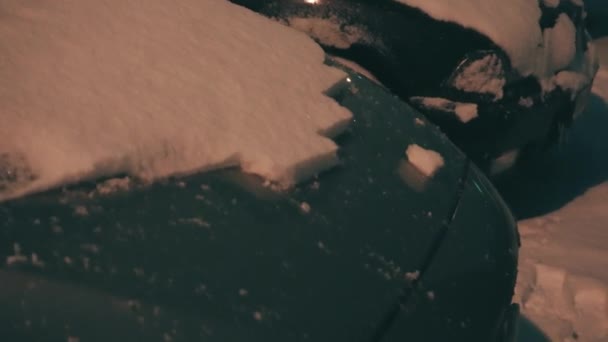 雪の後 寒い冬の夜に若い男が車から雪を削除します 男性の手は彼の車から雪を削除します 冬の輸送 車のケアと車のケアの概念 — ストック動画