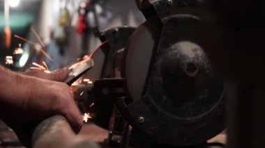 Elektrikli değirmen çarkında balta keskinleştirmek, makine elektrikli öğütücüde balta bilemek, dönen taşta bilemek, yakın plan.