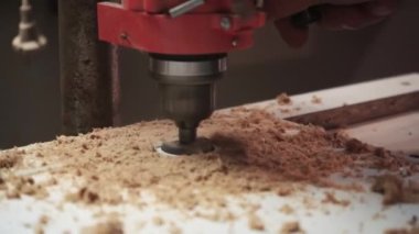 Tahtadaki deliği öğütmek. Fabrika işçisi iş başında. Kontra-lavabo matkabı deliğe batırır. İnsan ahşap tahtada delik açmak için sondaj makinesi kullanır.