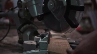 Erkek marangoz, bir marangoz atölyesinde dairesel testere ile tahtayı kesiyor. Dairesel testere. Marangoz tahta için testere kullanıyor.