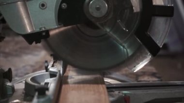 Erkek marangoz, bir marangoz atölyesinde dairesel testere ile tahtayı kesiyor. Dairesel testere. Marangoz tahta için testere kullanıyor.
