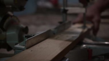 Erkek marangoz, bir marangoz atölyesinde dairesel testere ile tahtayı kesiyor. Dairesel testere. Marangoz tahta için testere kullanıyor.