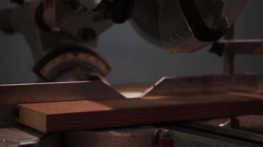 Erkek marangoz, bir marangoz atölyesinde dairesel testere ile tahtayı kesiyor. Dairesel testere. Marangoz tahta için testere kullanıyor.