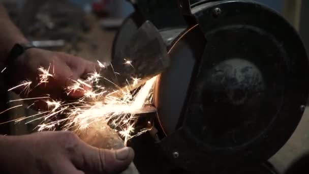 在电动砂轮上削尖斧头 在电动磨床上削尖斧头 在旋转磨石上手工削尖 — 图库视频影像