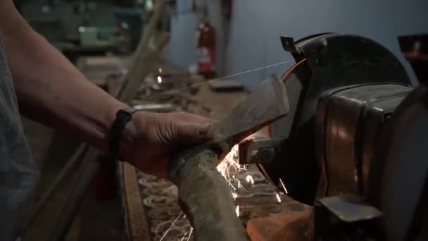 在电动砂轮上削尖斧头 在电动磨床上削尖斧头 在旋转磨石上手工削尖 — 图库视频影像