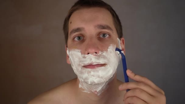 수염을 화장실에서 콧수염을 만들기 일회용 면도기를 사용하는 사람은 면도를 피부에 — 비디오