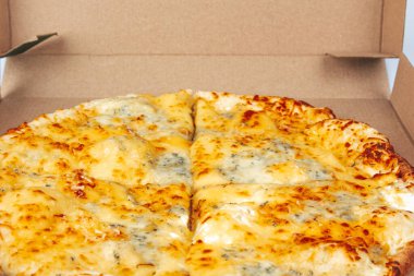 Beyaz arka planda izole edilmiş karton bir kutuda pizza. Pizza paketlemenin en üst görüntüsü. Lezzetli, sulu, lezzetli yemekler. Atıştırmalık Kötü fast food.