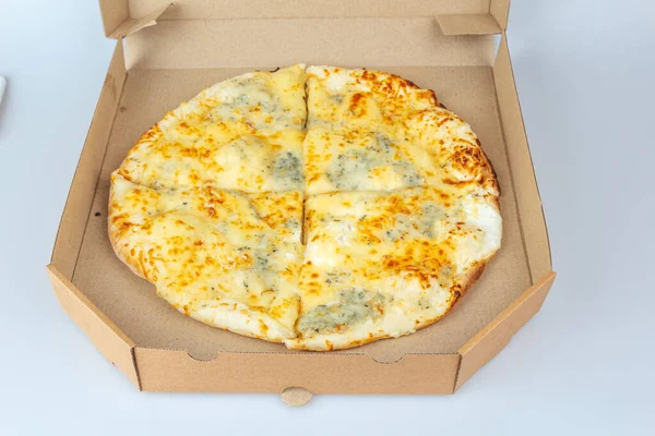 Pizza in a cardboard box isolated on a white background. Top view of pizza packaging. Delicious, juicy, flavorful food. Quick snack. Bad fast food