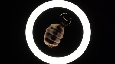 female hands hold adjustable spanner. adjustable wrench on a black background close-up. hand tool for repair. manual work.