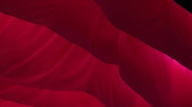 Light flowing red fabric imitating waves. The concept of lightness, female beauty, tenderness. Air show. Association with womens critical days
