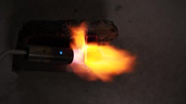 Ignition of two coconut coals for a hookah with a gas burner. Close-up of kindling coals for hookah