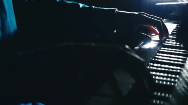 Piano keys close up in dark colors. Student trains to play the piano. Man two hands plays gentle classical music on a beautiful grand piano in a classroom close up