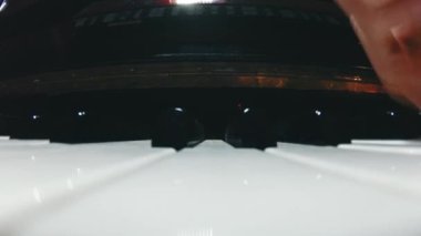 The student is learning to play the piano. A man with two hands plays a beautiful piano in the classroom close-up. Shot with a wide angle camera. Fish eye