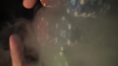 Close-up of a player pushing his chips in the middle of a poker table, shot in slow motion. vertical video