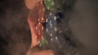 Close-up of a player pushing his chips in the middle of a poker table, shot in slow motion. vertical video