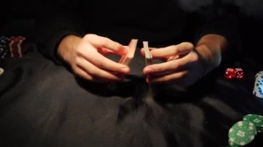 Poker table during the game. The player holds the cards in his hands. Chips and cards on the table. Gambling theme