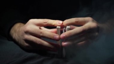 Casino: The hands of a male dealer shuffle poker cards. Tricks with cards
