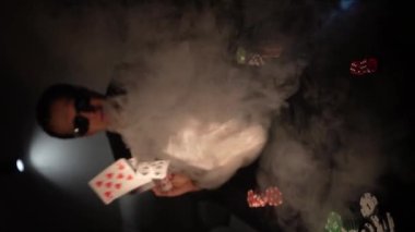Bearded man plays poker in a casino. The person wins and effectively throws the cards on the table. Slow motion. vertical video