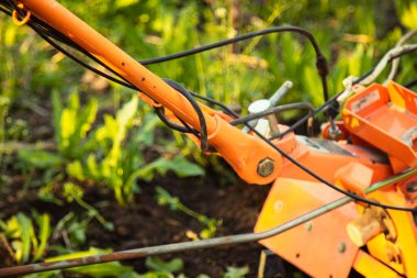 a small agricultural tractor plows the ground, the work of a walk-behind tractor. land treatment for planting