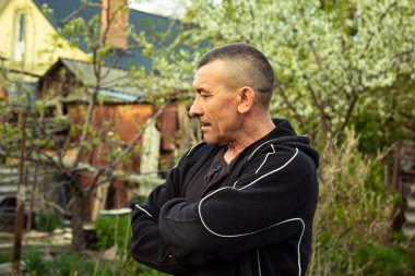 Planting vegetables under the walk-behind tractor. A man with a walk-behind tractor in the garden. Manual work with equipment. An elderly man teaches a young boy to plow the land