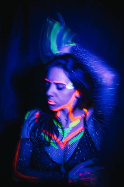 Model woman in neon light, beautiful model girl with fluorescent makeup, art design of disco dancer dancing in uv light, colorful makeup. Nightclub, Party. 4K video