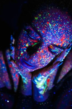 Model woman in neon light, beautiful model girl with fluorescent makeup, art design of disco dancer dancing in uv light, colorful makeup. Nightclub, Party