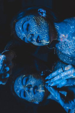 Woman model in neon light, beautiful model girl with fluorescent make-up, artistic design. Blue tinted photo. Marine photo concept. Cosplay avatar