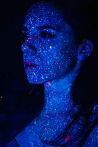 Portrait of a beautiful woman with blue sequins on her face. Girl with artistic make-up in Light color. Fashion model with colorful makeup