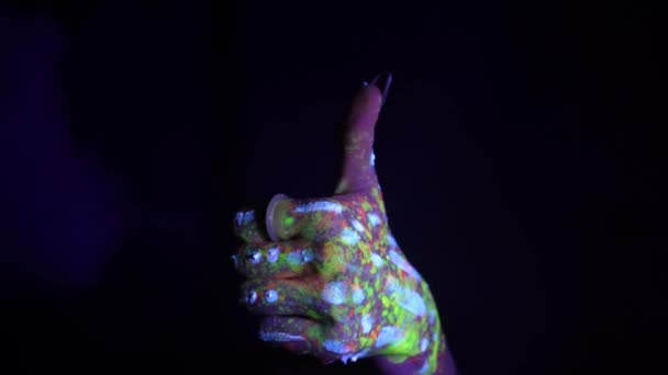 蛍光色の民族模様の手が親指を上げています 蛍光塗料 ボディアートの概念 暗闇の中で成長する ジェスチャー 手の動き — ストック動画