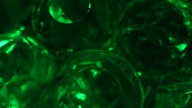 Water color gel balls. Super macro bubbles slow motion. Bubbles of water. Liquid cream gel transparent cosmetic texture sample with bubbles. Background with hydrogel balls with glitter
