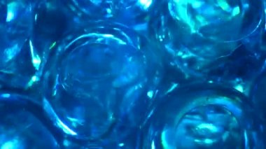 Su rengi jel topları. Süper makro kabarcıklar yavaş çekimde. Su kabarcıkları. Köpüklü sıvı krem şeffaf kozmetik doku örneği. Arkaplanda parıltılı hidrojel topları var