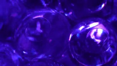 Water color gel balls. Super macro bubbles slow motion. Bubbles of water. Liquid cream gel transparent cosmetic texture sample with bubbles. Background with hydrogel balls with glitter