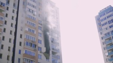 Kyiv, Ukraine - November 15, 2022: Smoke comes from burning rooms in a multi-storey building. Fire in the apartment. Thick black smoke is coming from the windows of the apartment. Putting out a fire