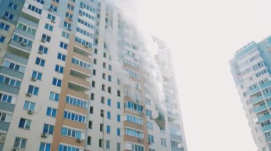 Kyiv, Ukrayna - 15 Kasım 2022: Duman çok katlı bir binadaki yanan odalardan geliyor. Apartman yangını. Kalın siyah duman dairenin pencerelerinden geliyor. Yangını söndürüyorum.