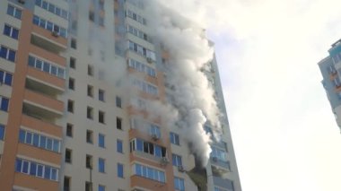 Kyiv, Ukraine - November 15, 2022: Smoke comes from burning rooms in a multi-storey building. Fire in the apartment. Thick black smoke is coming from the windows of the apartment. Putting out a fire