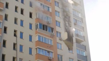 Kyiv, Ukrayna - 15 Kasım 2022: İtfaiyeci yangını söndürmek için duvarlara su püskürttü. Bir sürü duman yükseliyor. Büyük bir yangın sırasında kırık camlardan çıkan ateş ve kalın gri duman