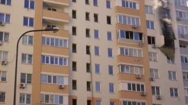 Kyiv, Ukraine - November 15, 2022: Smoke comes from burning rooms in a multi-storey building. Fire in the apartment. Thick black smoke is coming from the windows of the apartment. Putting out a fire