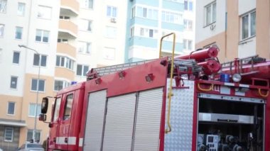 KYIV, UKRAINE - NOVEMBER 15, 2022: A red fire engine stands in front of a burned-out apartment in a multi-storey residential building. Fire after exploding generator