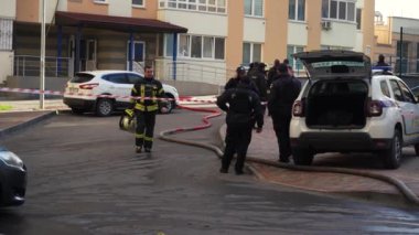 KYIV, UKRAINE - NOVEMBER 15, 2022: Uniformed fireman closes a roller shutter on the side of a fire engine. The end of the working day, the fire is extinguished. The concept of finishing a dangerous