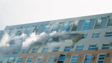KYIV, UKRAINE - NOVEMBER 15, 2022: Fire in the apartment. Thick gray smoke comes from the windows of an apartment building. Extinguishing a fire in an apartment building. vertical video