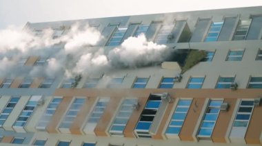 KYIV, UKRAINE - NOVEMBER 15, 2022: Fire in an apartment building. Blue smoke billows from the windows of the apartment. Extinguishing a fire in an apartment building. vertical video