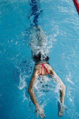 Successful female swimmer swimming in the pool. A professional athlete is determined to win the championship