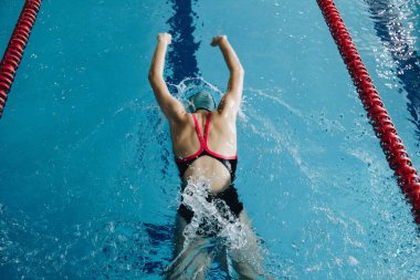 Successful female swimmer swimming in the pool. A professional athlete is determined to win the championship