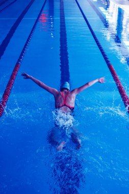 Successful female swimmer swimming in the pool. A professional athlete is determined to win the championship