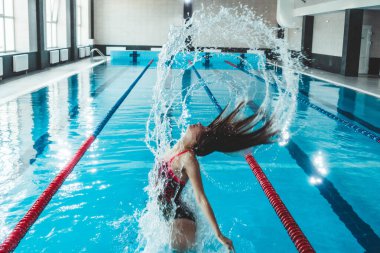 Synchronized girl working out tricks in the pool. Synchronized swimming, sports in the water. Healthy lifestyle