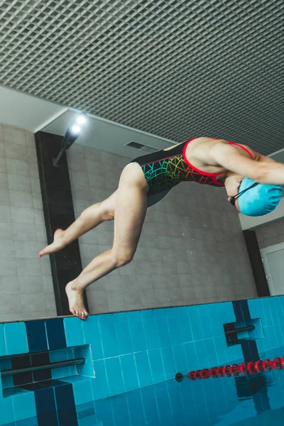 stock image The girl is engaged in synchronized swimming in the pool. Pool jump trick. The swimmer jumps into the pool