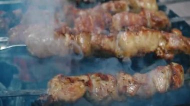 Yakın plan et şişleri. Şişte barbekü. Izgara ızgara. Boş zaman, yemek, insanlar, tatiller. Kavram - bir adam arkadaşları için barbekü ızgarasında et pişirir.