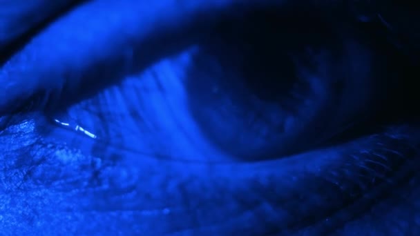 緑の虹彩で目を閉じる 健康的なビジョンの概念 ネオンライトの男の青い目 ナイトクラブの若い男 人間の目のマクロビュー 青い色 幸福感 — ストック動画